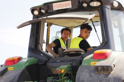 Un dels joves que participen en el curs de tractoristes segueix les indicacions de l’instructor en una maniobra.