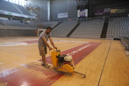 Un operari de l’empresa contractada, ahir tallant els panells de fusta abans de retirar-los.