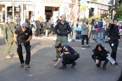 La policia inspecciona els danys al lloc de l’explosió.