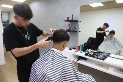Arnau Farré, el barber de 20 anys que ha obert el seu negoci a les Borges, ahir amb un client. - MAGDALENA ALTISENT