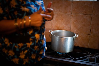 Imagen de archivo de una mujer cocinando en una cocina de gas.