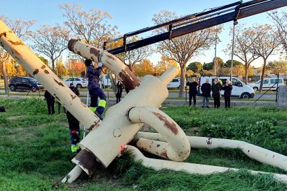 Els operaris carreguen les peces de l'escultura a un camió ploma per traslladar-la.