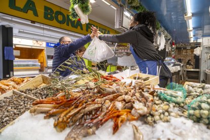 Un client adquireix marisc a la peixateria Jaume Soria del Mercat de Fleming de Lleida.