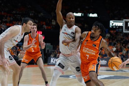 El jugador del Valencia Basket Chris Jones (dcha) controla el balón ante el jugador del Hiopos Lleida Kenny Hasbrouck (2d), durante el partido de la jornada 14 de la Liga Endesa disputado en el pabellón de la Fuente de San Luis de Valencia.