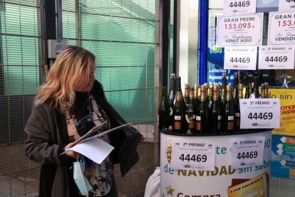 Una treballadora de l'adminstració de loteria del centre comercial Arenas de Barcelona preparant ampolles de cava per celebrar que el local ha repartit un premi del Nen en una imatge d'arxiu.