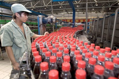 En la imagen de archivo, un trabajador comprueba las botellas de refresco en la línea de control de calidad de la embotelladora de Hangzhou, China.