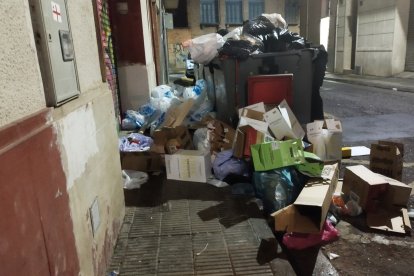 Contenedores repletos de basura, que ocupa la acera de la calle Ramon Soldevila.