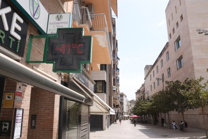 Imatge del carrer de Pi i Margall de Lleida, amb gent a l'ombra i un termòmetre que indica una temperatura superior als 40 graus