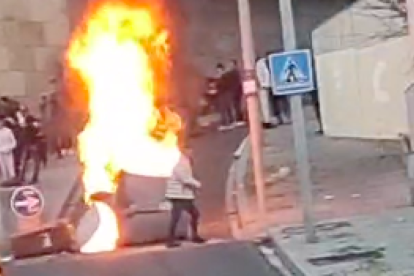 Un contenidor en flames durant l'aldarull a la plaça Joan Solans.