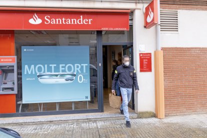 Un agente de investigación de los Mossos d’Esquadra ayer por la tarde en el banco asaltado. - JORDI ECHEVARRIA