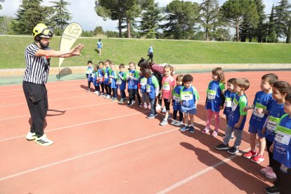Un bomber parla amb un grup de nens abans de començar una carrera, sense caràcter competitiu. - MAGDALENA ALTISENT