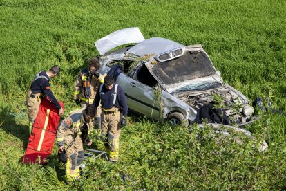 Bombers al costat del vehicle sinistrat. - LAIA PEDRÓS