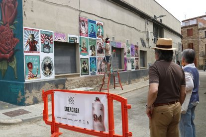 Un dels artistes treballant al seu mural. - ACN