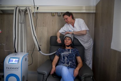 La enfermera de la unidad de Oncologia de Vithas muestra de forma simulada el funcionamiento del gorro que ponen a los pacientes. - GERARD HOYAS