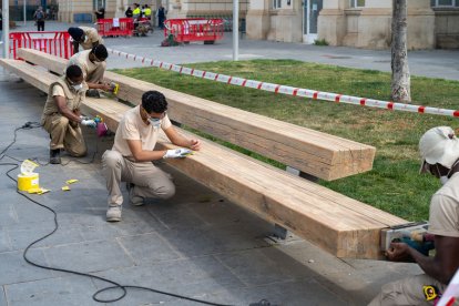 Alumnos del IMO trabajando ayer en los bancos de madera frente a la estación. - AJUNTAMENT DE LLEIDA
