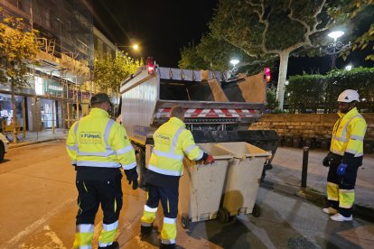 Personal vacía en el camión de recogida de basura los cubos del nuevo sistema puerta a puerta parcial en Tàrrega