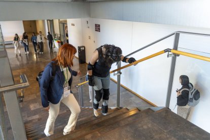 Una voluntaria equipada con el traje subiendo con dificultad las escaleras. - PAU PASCUAL