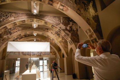 Un vistitante, tomando fotos de los murales de Sijena en el MNAC. - KIKE RINCÓN / EUROPA PRESS