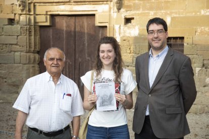 Joan Riu, responsable de la parròquia, Mariona Armengol i Ramon Gené amb el llibre de Sant Francesc. - C.MARSIÑACH