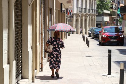 Una mujer se protege del sol con un paraguas este mediodía en Lleida.