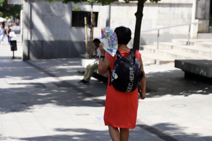 Una vianant es protegeix del sol a Lleida.