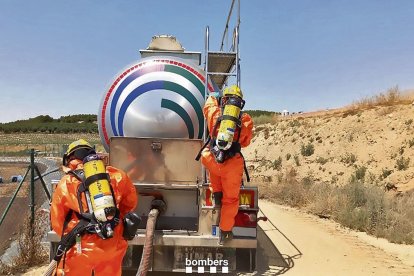 Dos bombers, durant la revisió del camió en el qual hi havia l’àcid sulfúric. - JORDI ECHEVARRIA