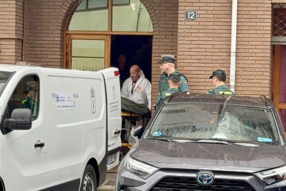 Agentes trasladan el cadáver de la mujer asesinada por su marido en Pola de Laviana. - EFE/J.L. CEREIJIDO