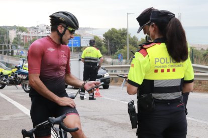 Un ciclista muestra su documentación a los Mossos d'Esquadra en un control de tráfico.