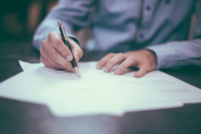 Una persona firmant un document.