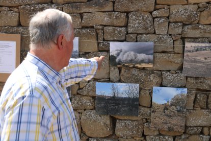 Joan Graells, veí de Granollers de Segarra, assenyala una fotografia de l'exposició de l'Incendi de Torrefeta i Florejacs.