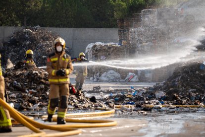 Bomberos trabajando este lunes en la extinción del incendio en una empresa del polígono Camí dels Frares de Lleida.