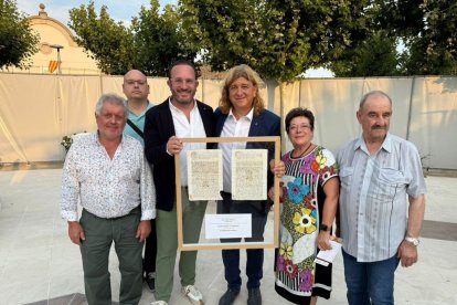 Marc Cerón i David Masot sostenen l’escriptura amb diversos membres de la corporació municipal.