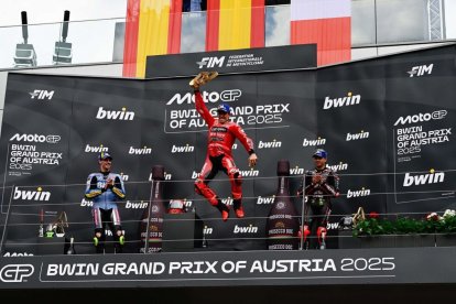 Marc Márquez salta en el podio con el trofeo de campeón en la mano, el noveno que logra en la carrera del domingo esta temporada. - MOTOGP