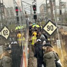 Viatgers caminant per les vies després de baixar del tren aturat.