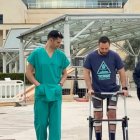El paciente camina a la puerta del hospital junto al doctor Luigi Albano.