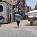 El paraigua s’ha convertit en un accessori imprescindible per protegir-se en les hores de més sol. - AMADO FORROLLA