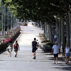 Vianants caminant per l'ombra a Lleida sota una intensa calor.
