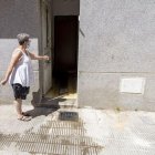 Una veïna mostra l’habitatge d’on surten les pudors a causa d’aigües fecals. - JORDI ECHEVARRIA