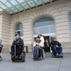 Usuaris de cadira de rodes davant l’estació de trens de Lleida. - S.E.