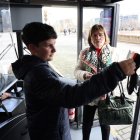 Dos viatgers validen el seu abonament de transport en un bus després de solucionar-se la incidència. - AMADO FORROLLA