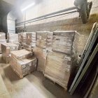 Imatge dels palets amb menjar, llits i estris de lavabo personal en un magatzem. A dalt a la dreta, anvers i revers d’una bossa amb una ració de menjar. - SCD