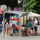 Diverses persones es refugien a l'ombra d'una parada d'autobusos a l'avinguda Blondel de Lleida durant l'onada de calor.