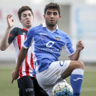 Un jugador del Lleida B controla la bimba davant de la pressió d’un rival.