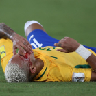 Neymar, ajagut a la gespa amb la cara ensagnada després del cop de colze que li va clavar un rival.