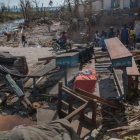 Un grup de persones observa una escola afectada pel pas de l’huracà ‘Matthew’, a Haití.