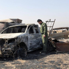 Un soldat de les forces kurdes peixmergues observa les restes d’un vehicle a prop de Mossul.
