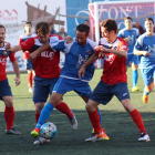 Dos jugadors del Balaguer pressionen per prendre la pilota a un futbolista del Vista Alegre.