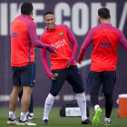 Neymar somriu ahir a l’entrenament davant de Luis Suárez i Messi.