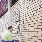 Un operari, repintant a sobre d’un grafiti al carrer Maragall aquesta setmana.