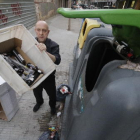 Un empleat d'un restaurant de Lleida llençant envasos de botelles al contenidor de reciclatge.